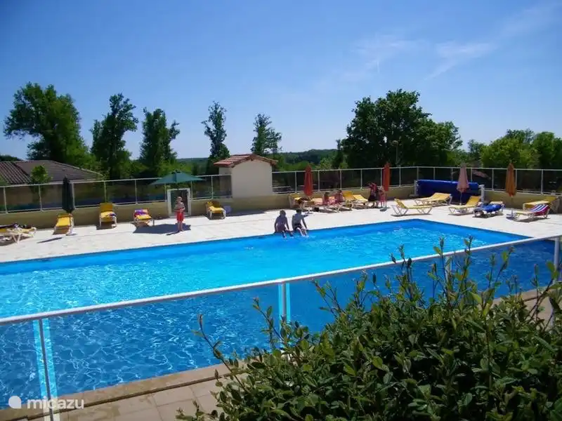La grande piscine avec transats et parasols.