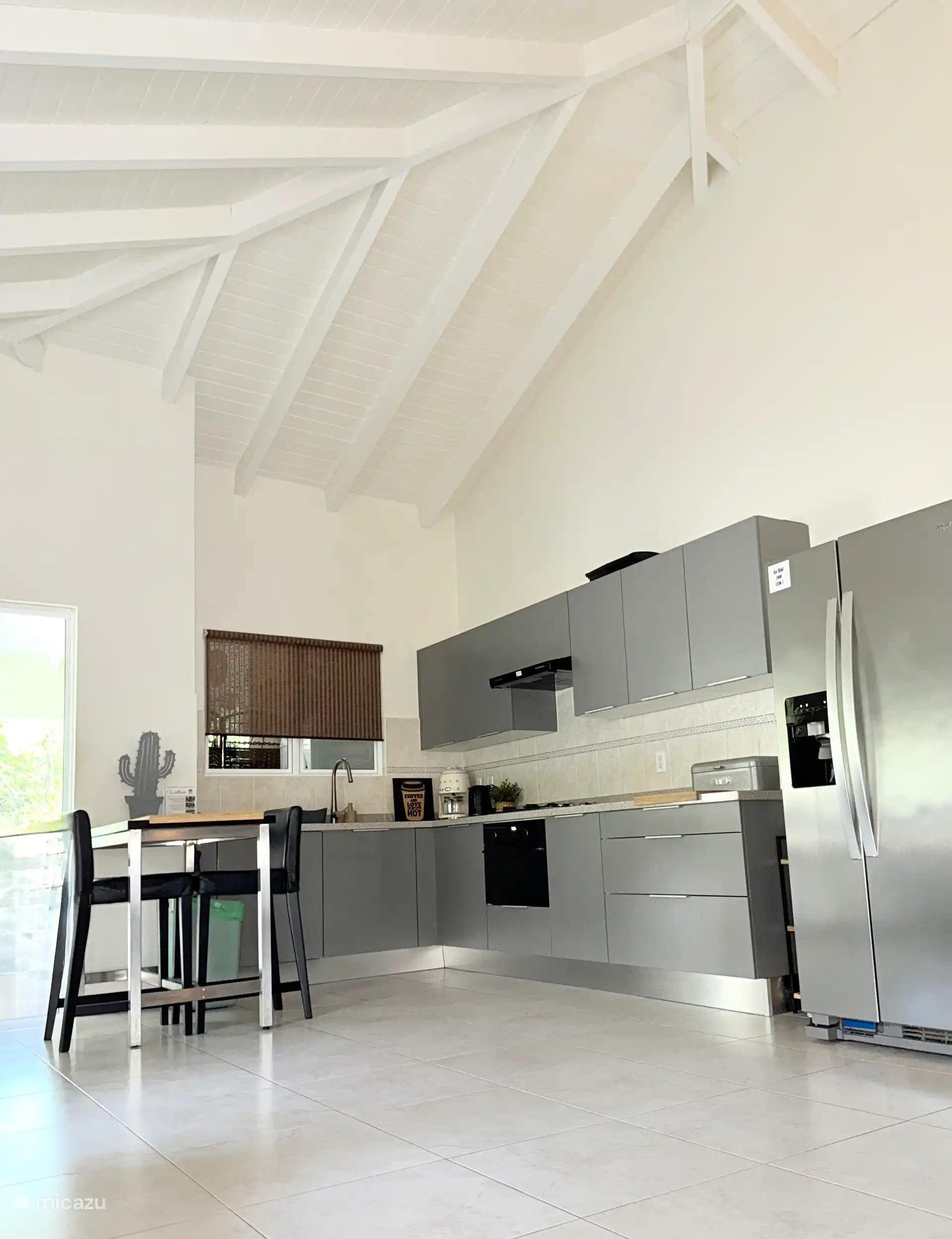 Voll ausgestattete Küche mit Geschirrspüler, Backofen, großem Kühlschrank, Mikrowelle und Filterkaffeemaschine.