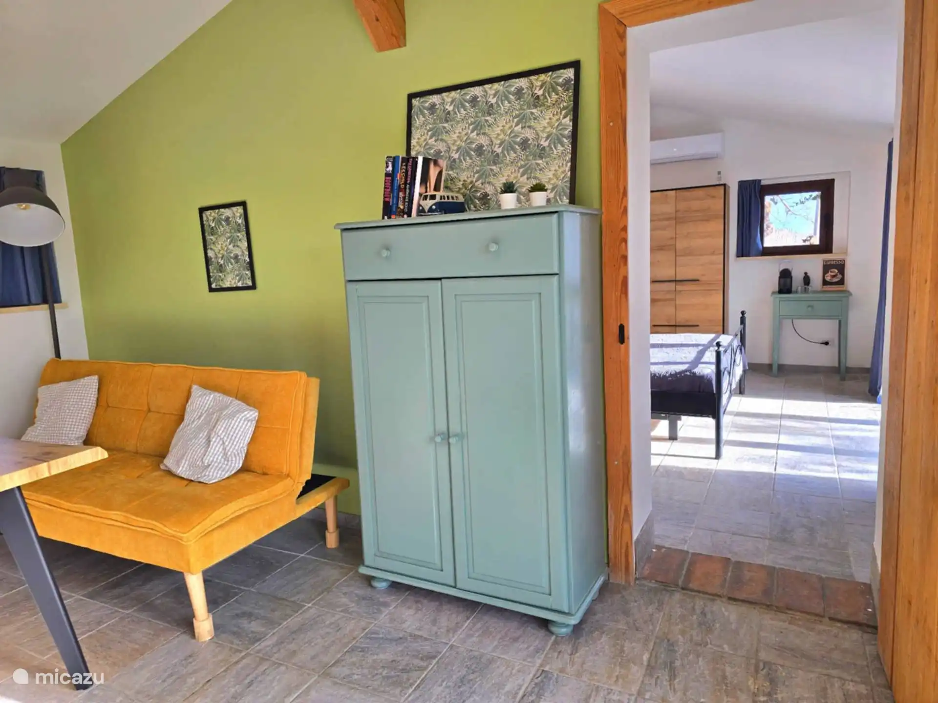 Zitruimte Fico die doorloopt naar de hoofdslaapkamer met koffiehoek.