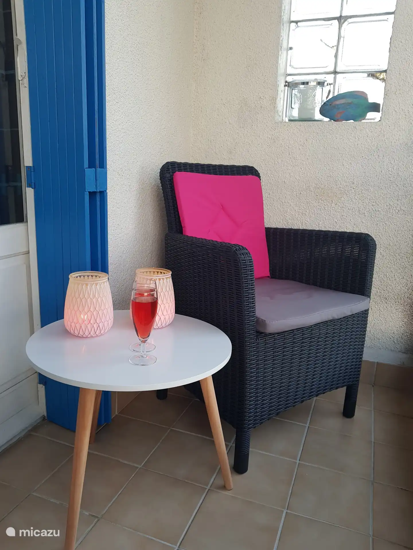 With a glass on the balcony.