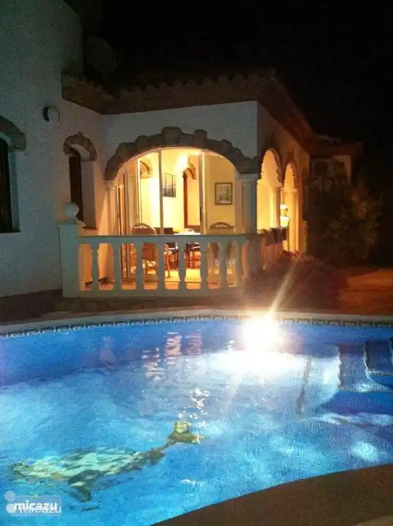 Zwembad en serre in het donker.