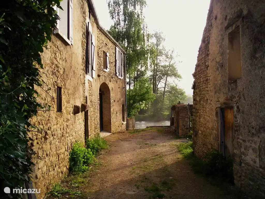 Weg zum Fluss entlang des Hauses. Gerade die Ruine einer Wassermühle