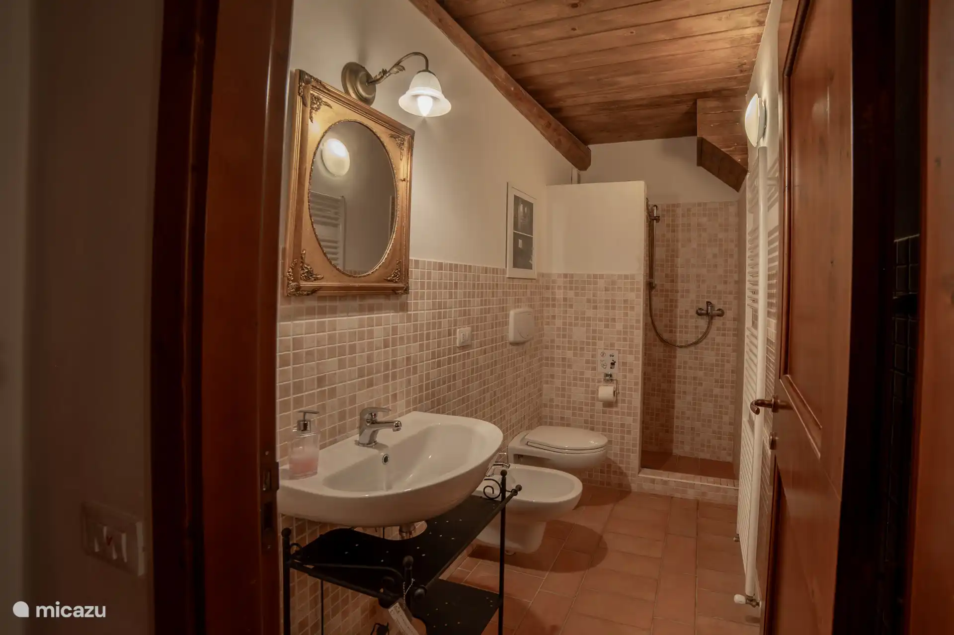 Badkamer met wastafel, toilet, bidet en douche.