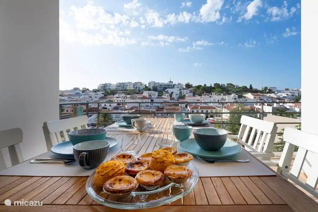 Schöne Aussicht vom Balkon auf den Dorfplatz von Ferragudo.