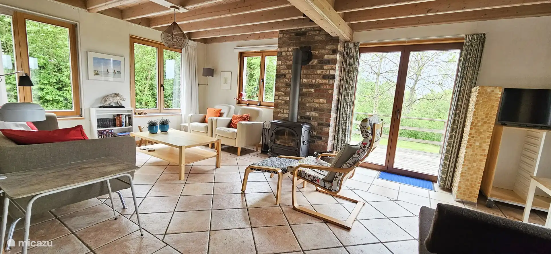 Geräumiges Wohnzimmer mit gemütlichem Kaminofen und Smart-TV