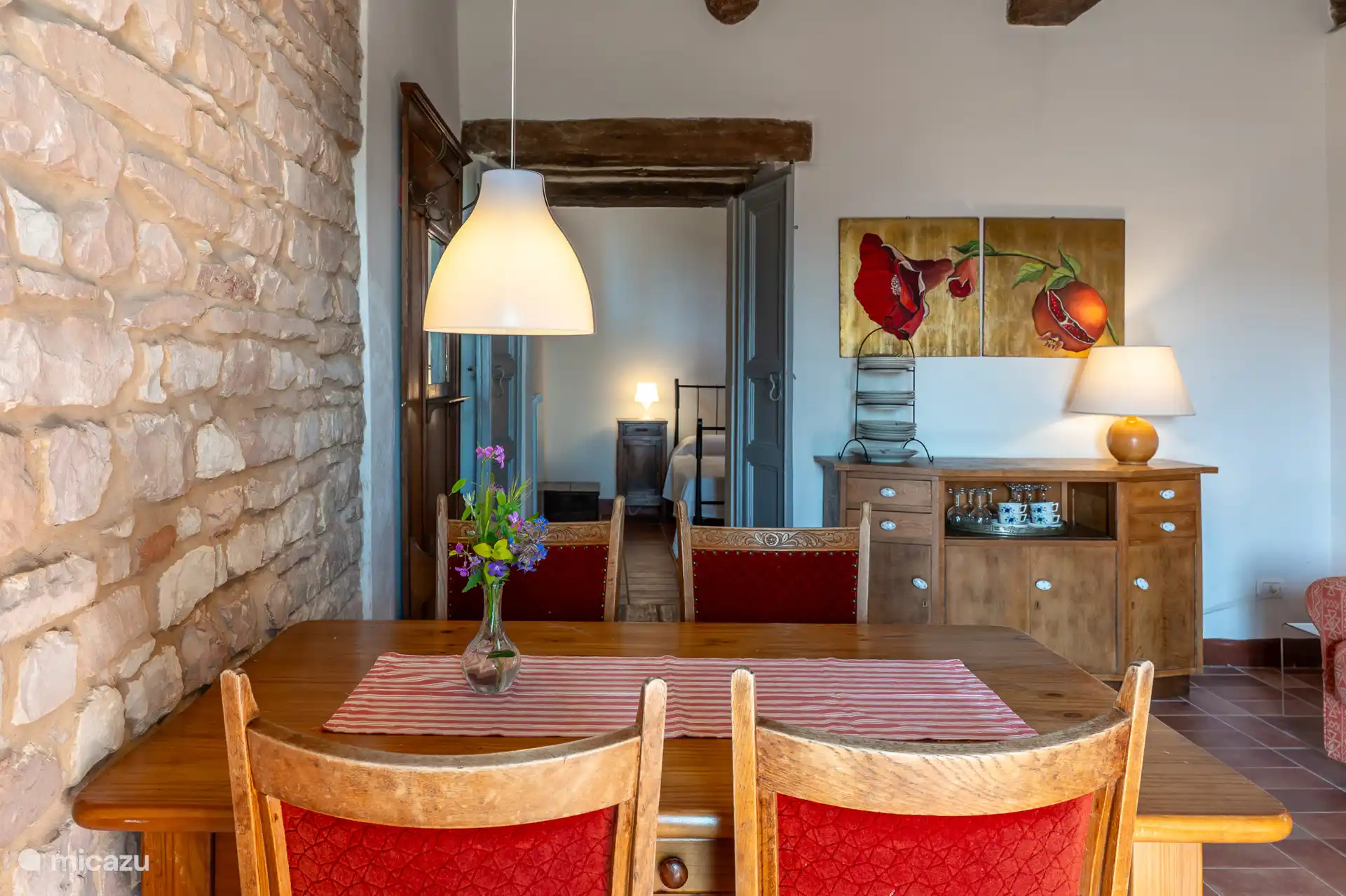 Vanaf de eettafel een doorkijkje naar de slaapkamer. Ontdek de vloeiende indeling van appartement Melograno.