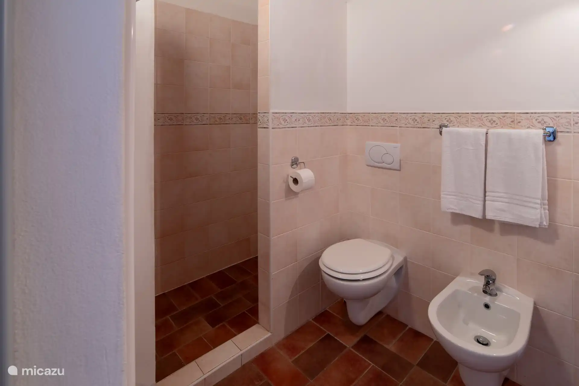 De lichte functionele badkamer van Melograno, afgewerkt met warme terracotta tegels en alle comfort dat je nodig hebt. 