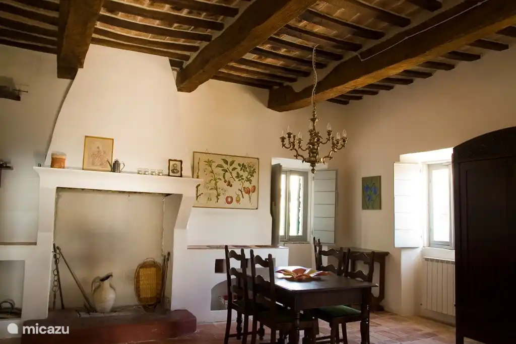 salón con sofá cama doble, cocina abierta y mesa de comedor