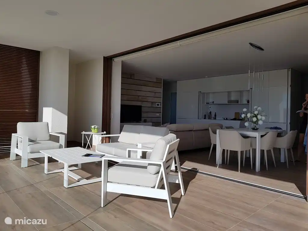 Zicht op het woongedeelte vanaf het terras met de schuiframen volledig geopend.