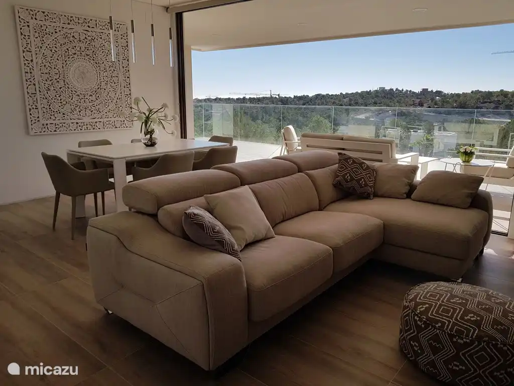 Ruim woongedeelte met open zicht op het zwembad en het domein. Het schuifraam kan volledig open zodat het terras en woongedeelte 1 open ruimte vormen.