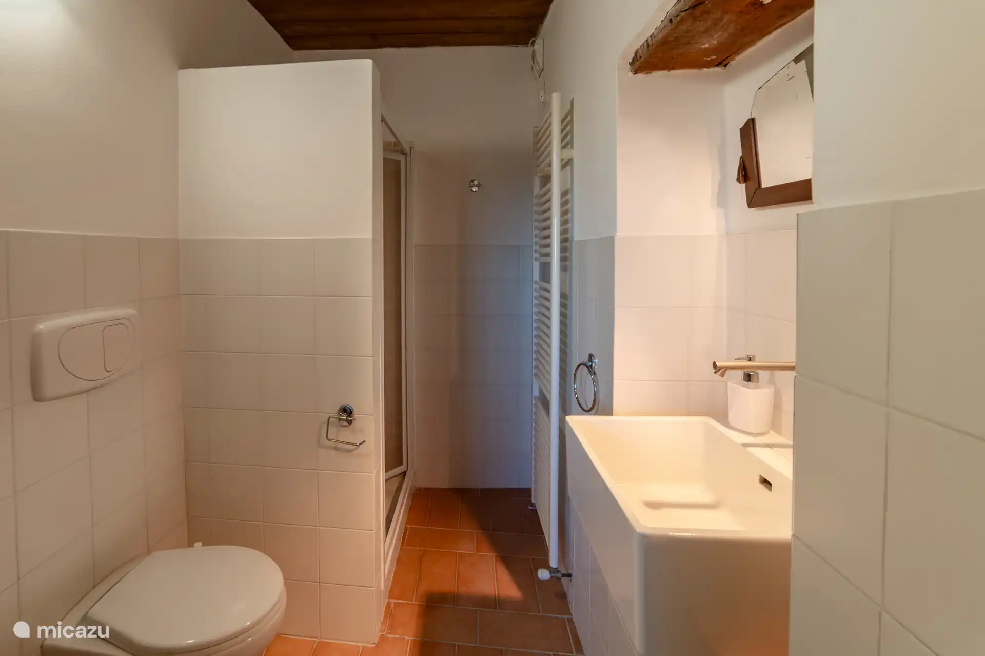 Lichte badkamer met een comfortabele inloopdouche. Praktisch ingericht en ideaal voor het hele gezin. Voorzien van een handige handdoekradiator voor warme handdoeken. 