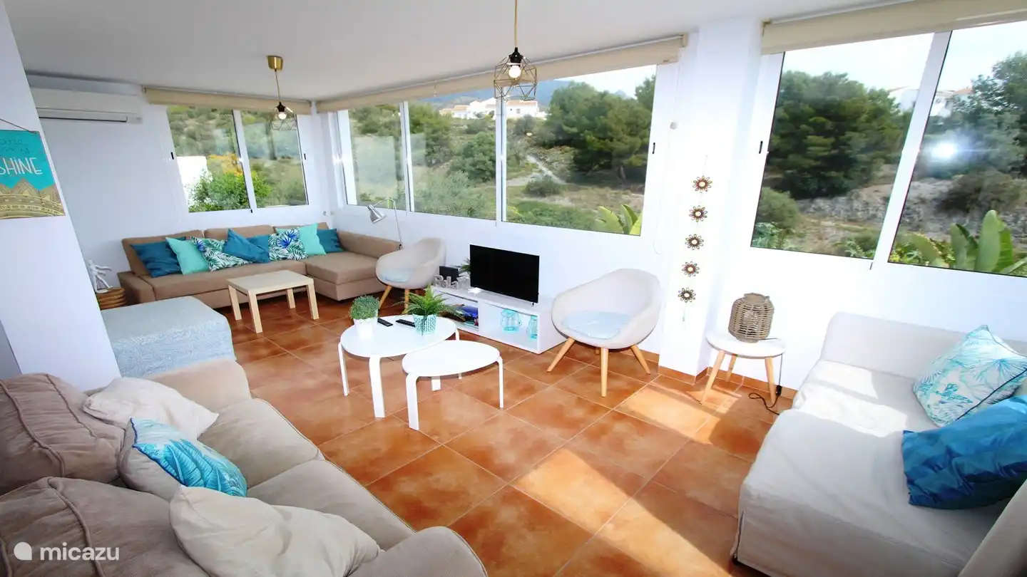 Wohnzimmer mit offener Küche und direktem Zugang zur Terrasse und Pool. Klimaanlage.