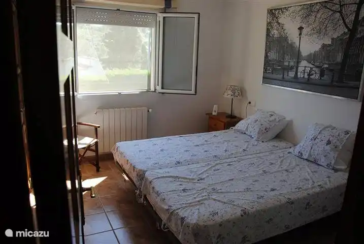 Schlafzimmer mit zwei getrennten Betten auf der vorderen Gartenseite.