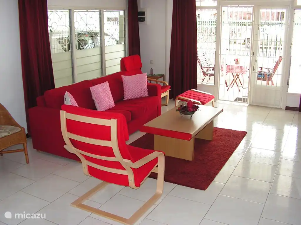 Sala de estar y balcón al frente visto desde la cocina. Toma de corriente de 220 voltios detrás del sillón con reposapiés.