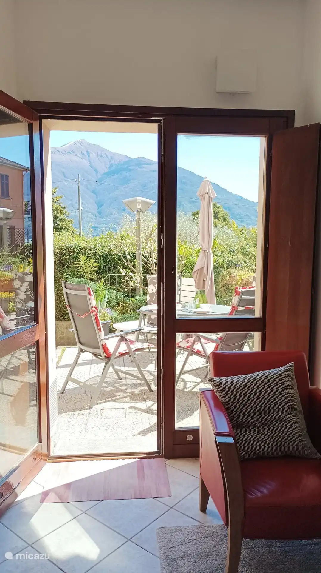 Vista desde la sala de estar a la terraza, a través del lago a las montañas al otro lado.
