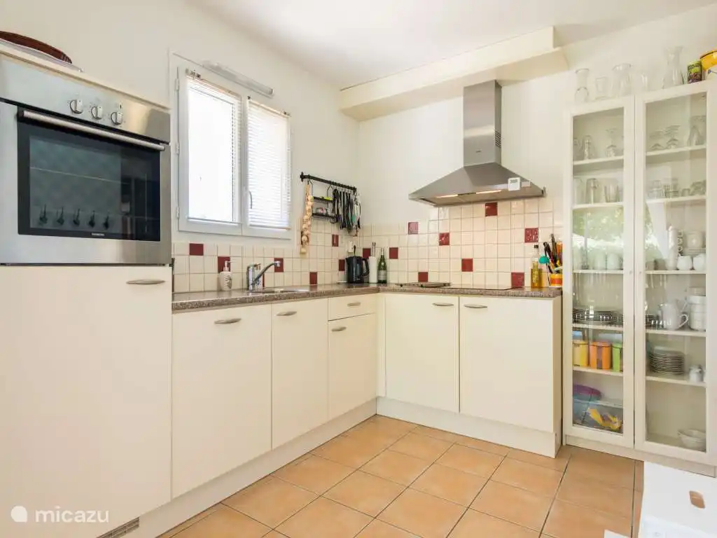 Cuisine spacieuse avec deux réfrigérateurs, micro-ondes, four et plaque à induction