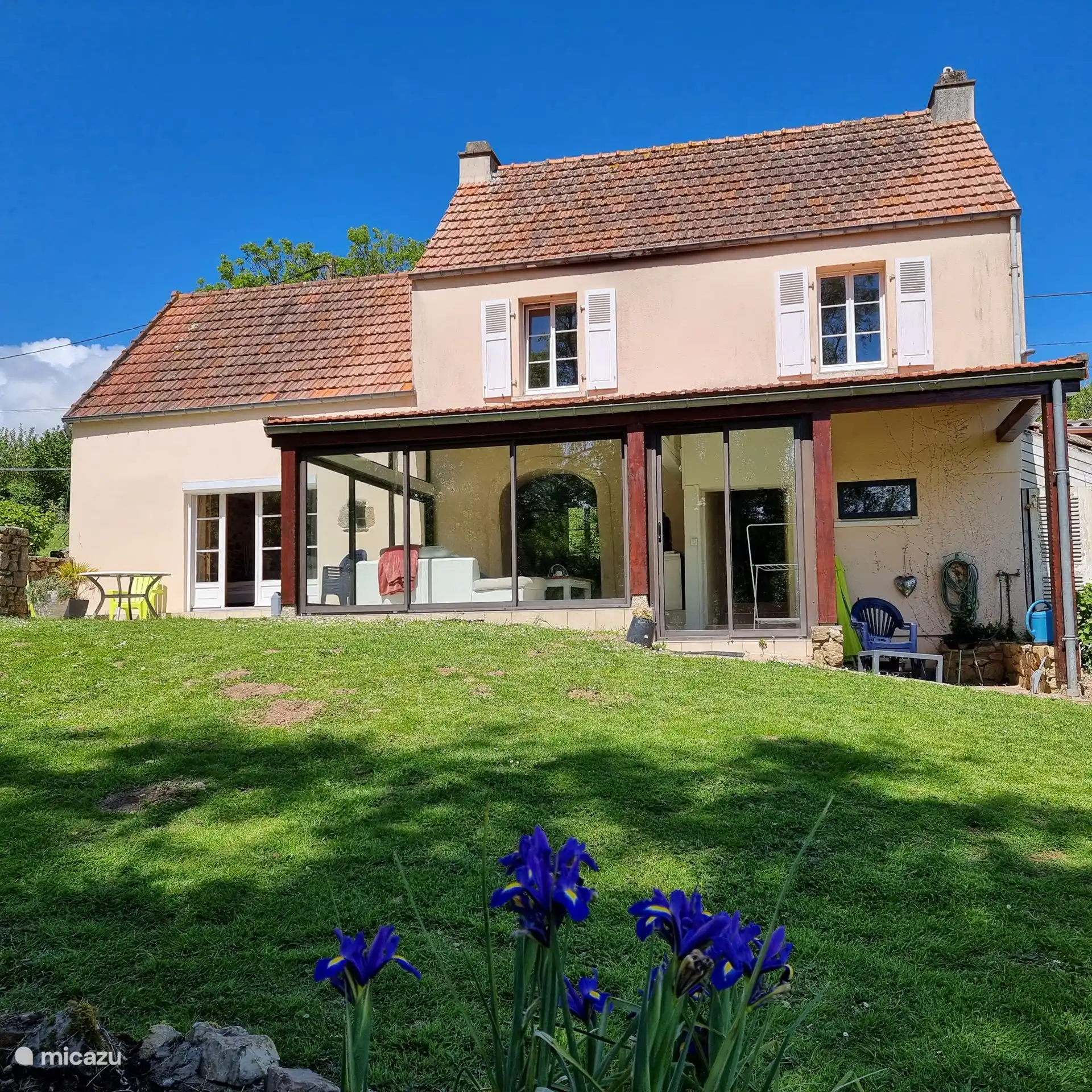 Geräumiger und heller Wintergarten mit bequemem großem Sofa und direktem Zugang zur Terrasse