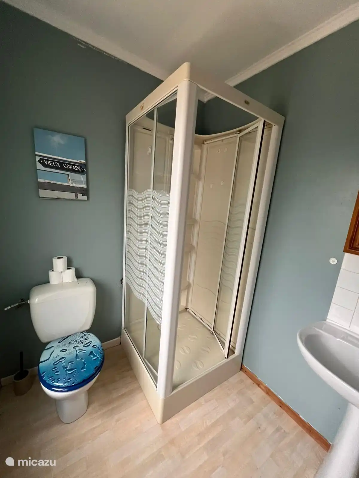 Retro-Atmosphäre im Badezimmer mit Meereselementen, altmodischem Waschbecken und schöner heißer Dusche. Beim Duschen kann hier das Fenster gekippt werden.