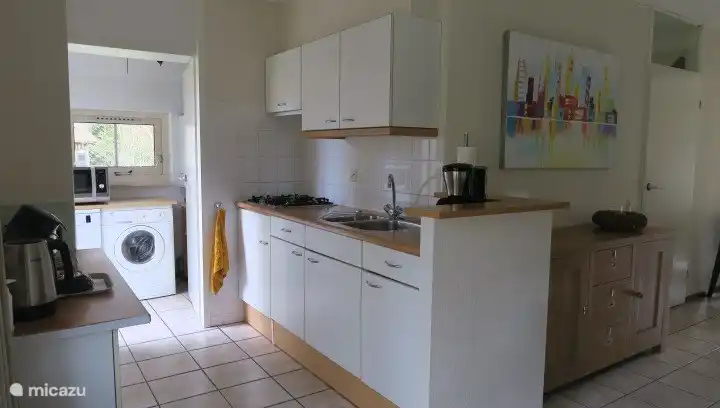 Küche mit Geschirrspüler, Kombi-Mikrowelle und Waschmaschine im Hauswirtschaftsraum 