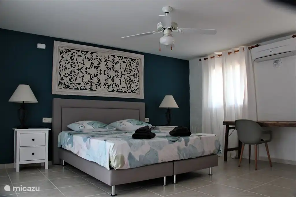 Das geräumige Schlafzimmer mit Einbauschränken, Ventilator und Klimaanlage.