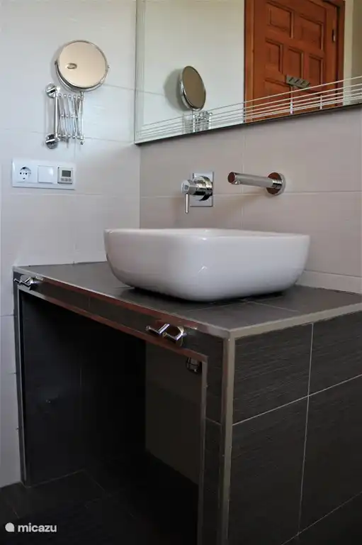 Komplettes Badezimmer mit begehbarer Dusche, Toilette und Waschbecken.