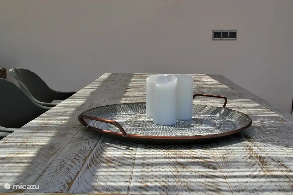 Großer Esstisch in der Veranda mit Stühlen und einer Bank.