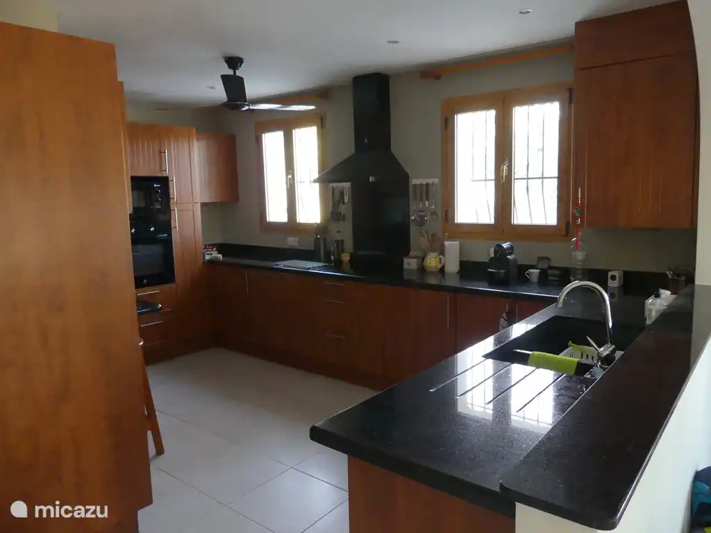 Komplette Küche mit Geschirrspüler, Waschmaschine und verschiedenen Küchengeräten.