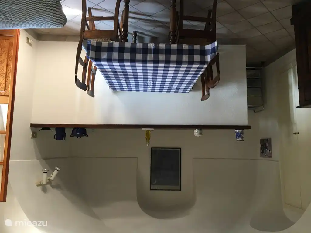 Einfache Küche mit Waschmaschine, Kühlschrank und Gasherd mit Backofen.