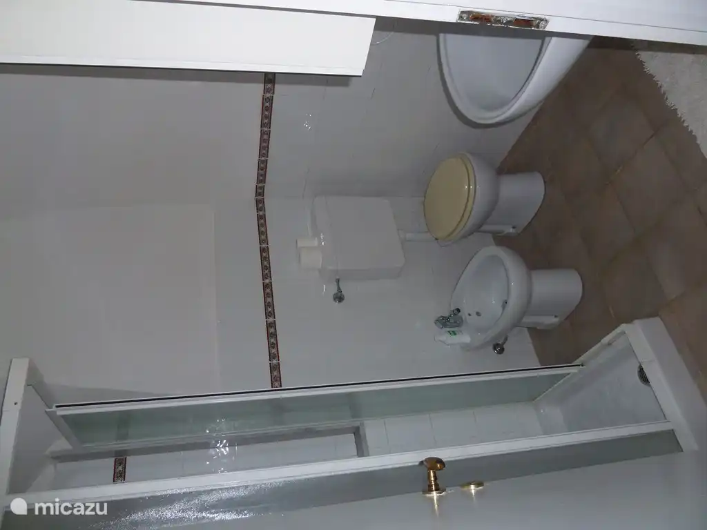 Badezimmer mit Duschkabine, Bidet, Toilette und Waschbecken.