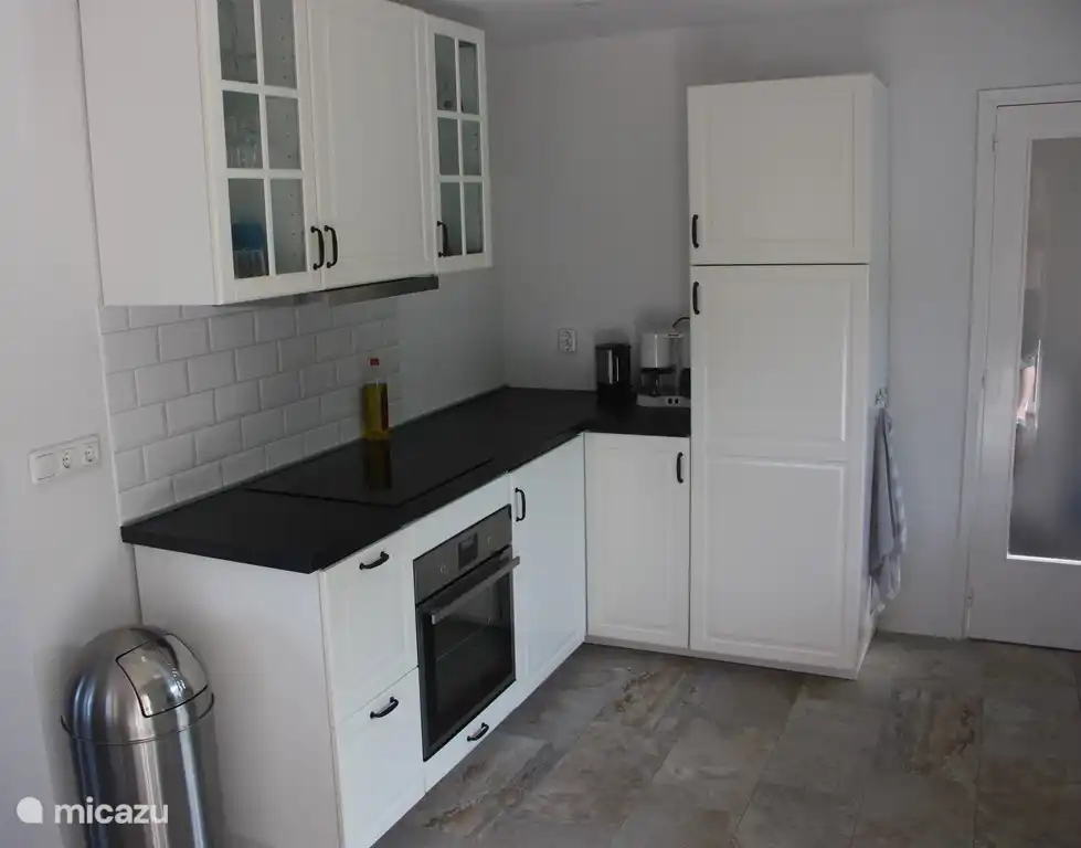 La cuisine spacieuse et moderne avec lave-vaisselle, 2 réfrigérateurs/congélateurs, plaques à induction, four et micro-ondes.