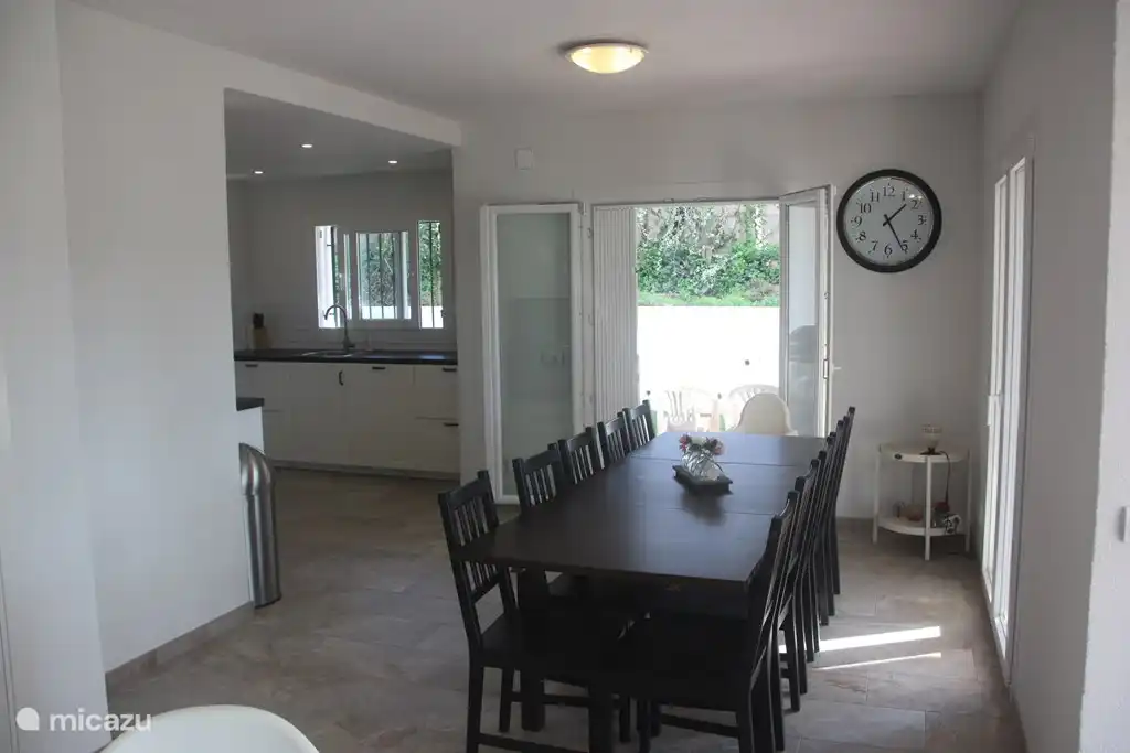 Grande table à manger à côté du salon et de la cuisine ouverte, 2 chaises hautes à disposition.