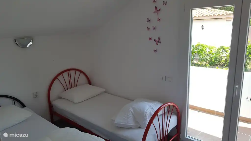 Chambre à l’étage avec 2 lits simples avec balcon et grande armoire.