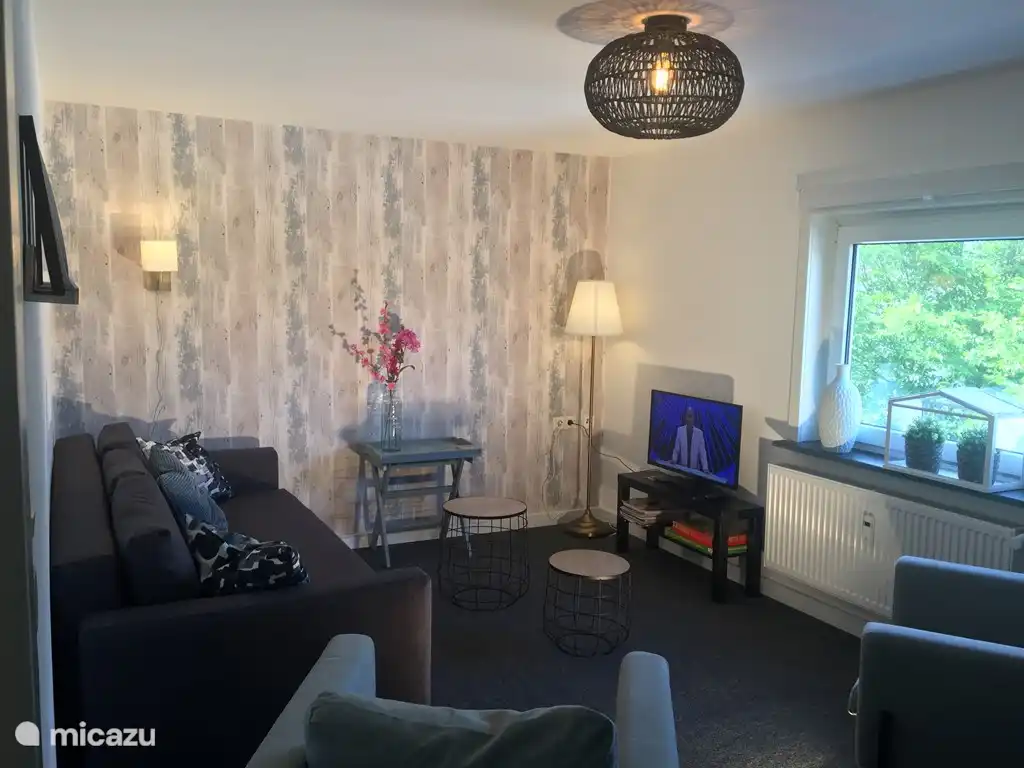 Wohnzimmer mit TV mit Satellitenschüssel und einem starken kostenlosen WLAN-Kanal.