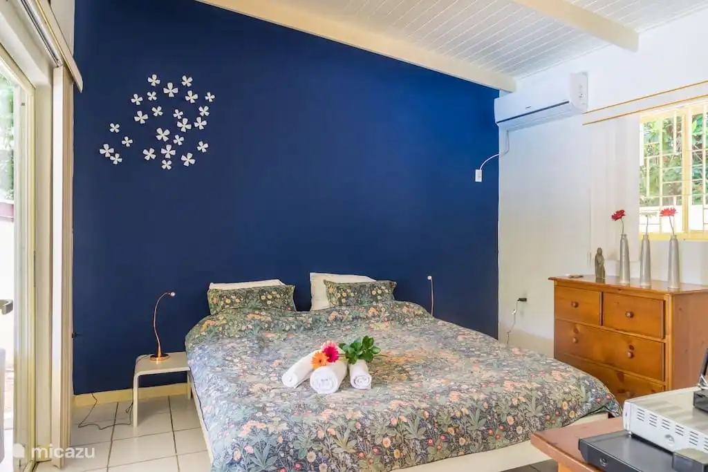 Bedroom with large double bed (180 x 210cm), TV, Airco, chest of drawers and spacious wardrobe, window with screen and sliding doors to the porch