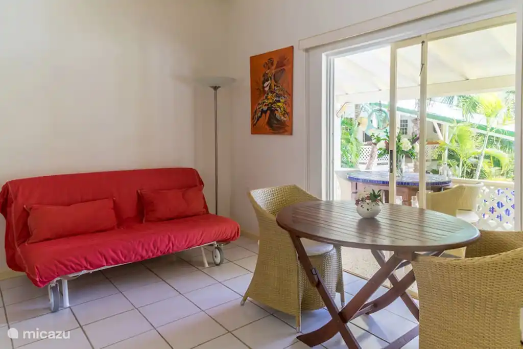Living room / open kitchen with double sofa bed (folded out 160 x 205cm), dining table and sliding doors to the porch.