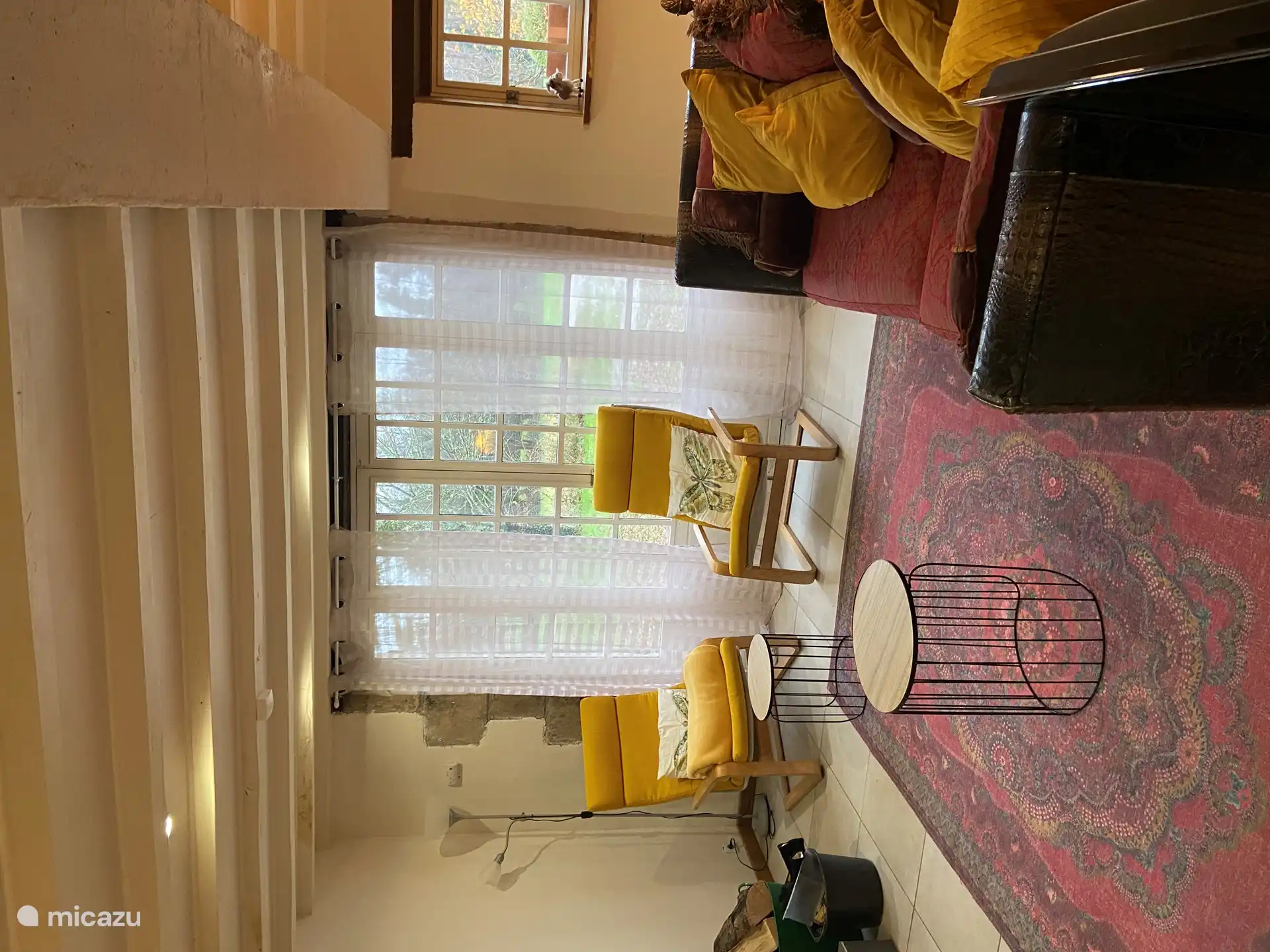 Die Wiese mit den Schafen und Ziegen ist durch die französischen Türen sichtbar.