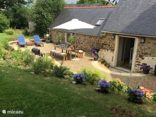 gîte / cottage huren in Frankrijk, Finistère, Locmaria-Berrien – La Colline des Renards zicht op het terras aan de achterkant van de Gite, een ruime prive terras met ligbedden, een grote tafel en een BBQ.
