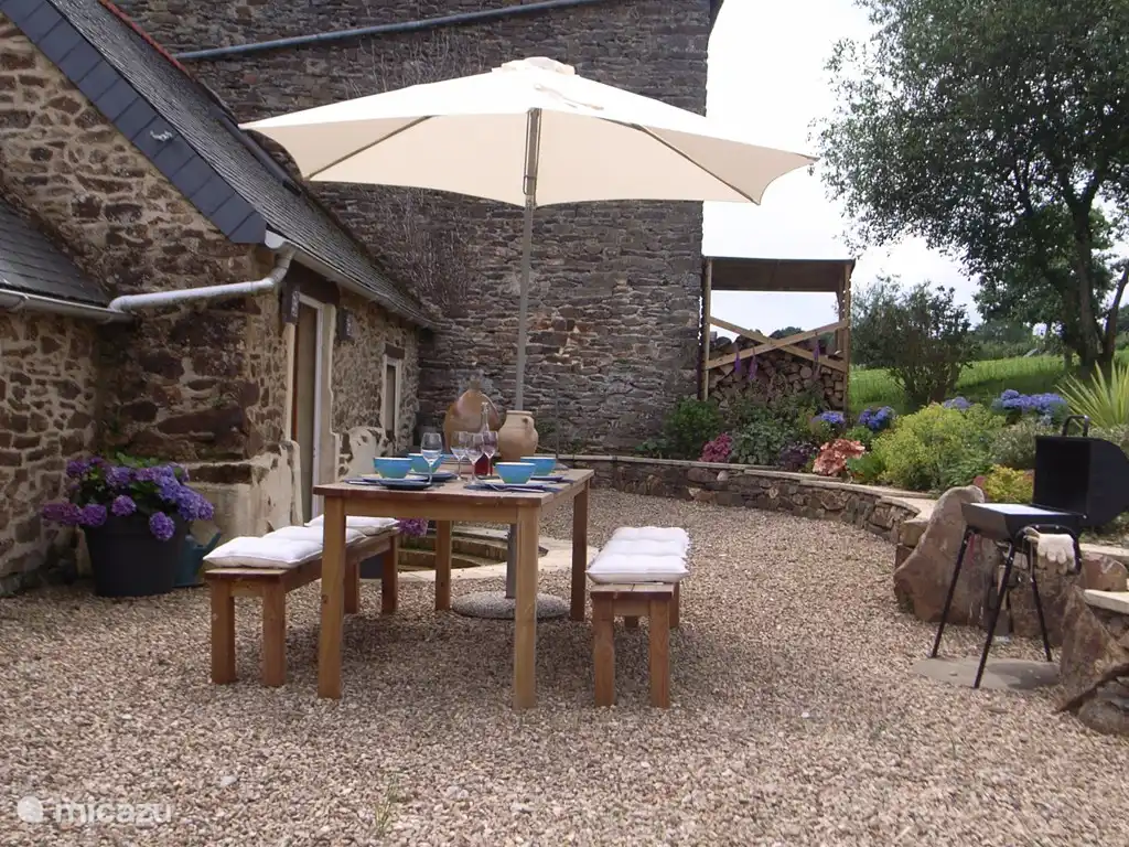 terras aan de achterkant van de Gite met een doorzicht naar de aangrenzende tuin die afgesloten is.