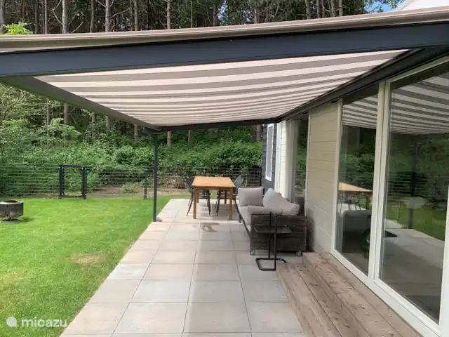 Bonita casa de vacaciones en la playa en Países Bajos, Holanda Meridional, Ouddorp - casa vacacional La terraza con mesa y 6 sillas, sofá cama y toldo