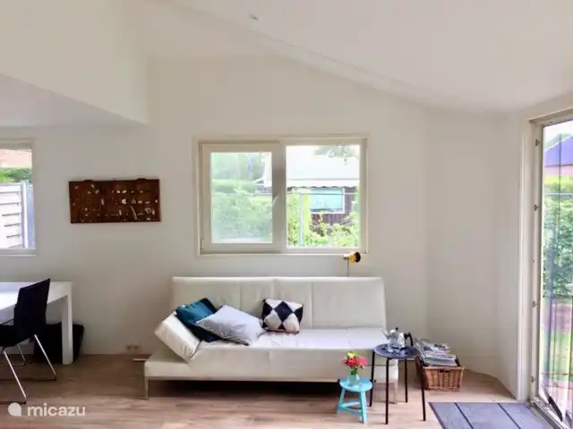 Bonita casa de vacaciones en la playa en Países Bajos, Holanda Meridional, Ouddorp - casa vacacional La sala de estar con un cómodo sofá.