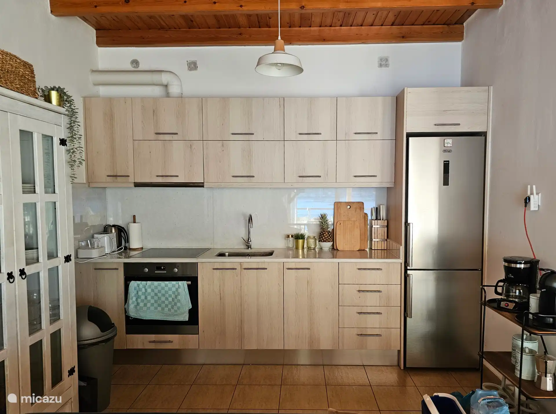 Kitchen with marble top, large fridge / freezer, electric hob, oven and various kitchen appliances