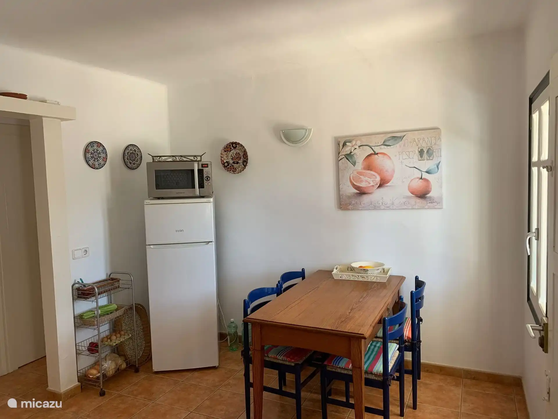 Amplia cocina con zona de comedor, microondas y nevera-congelador grande