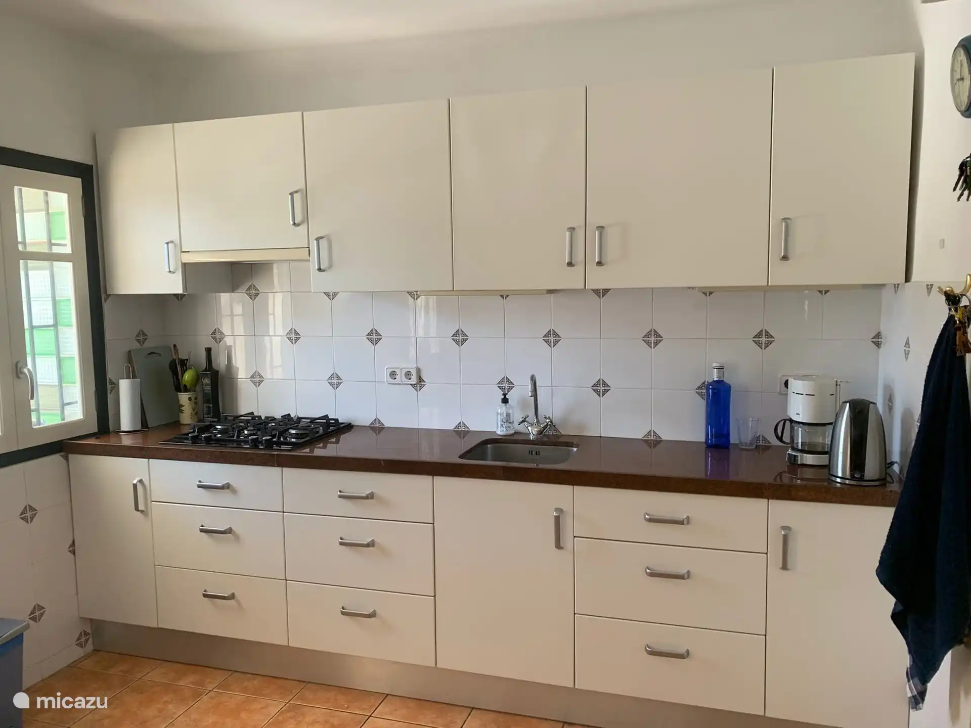 Amplia cocina con zona de comedor, microondas y nevera-congelador grande