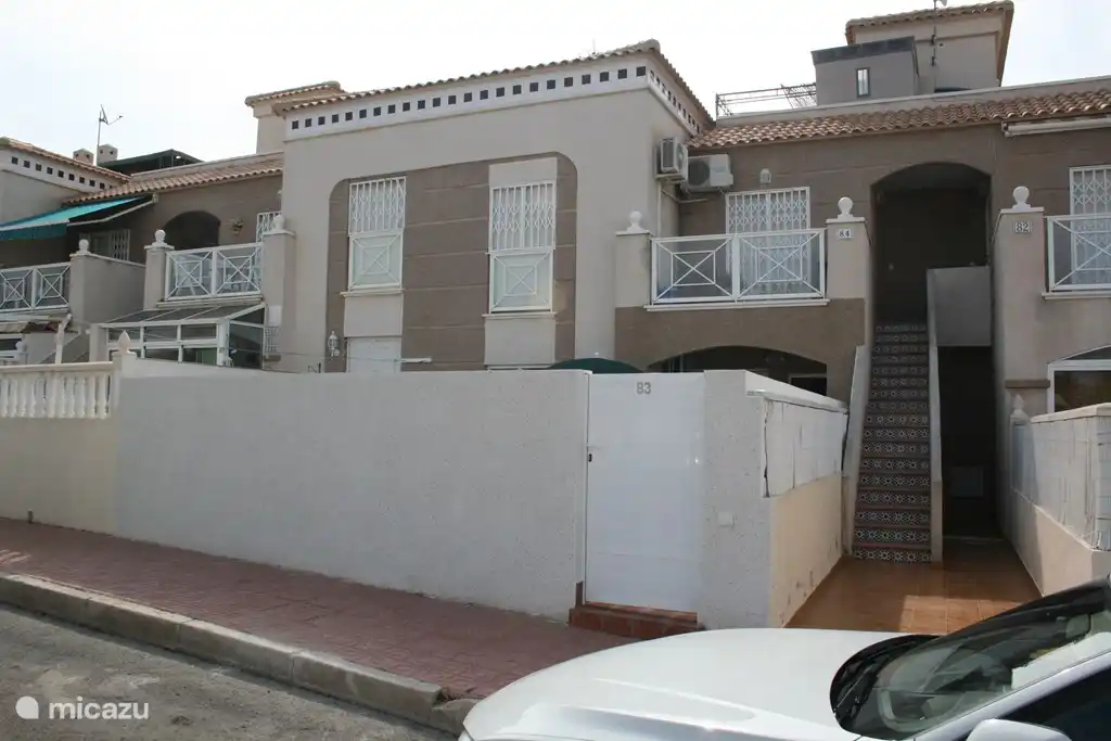 Vue de face : La terrasse ensoleillée est entourée d'un mur pour assurer une intimité totale.