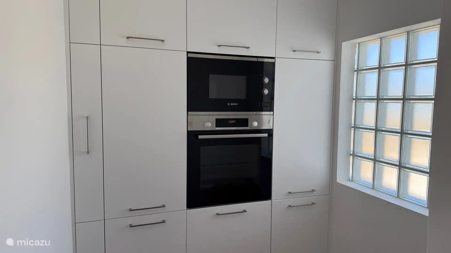 Bijkeuken met kastenwand en Bosch oven en Bosch magnetron