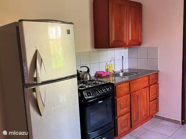 Casa Aruba | Aruba, Nord, Alto Vista - appartement Cuisine avec cuisinière à gaz, réfrigérateur-congélateur, casseroles, poêles, assiettes, verres et couverts