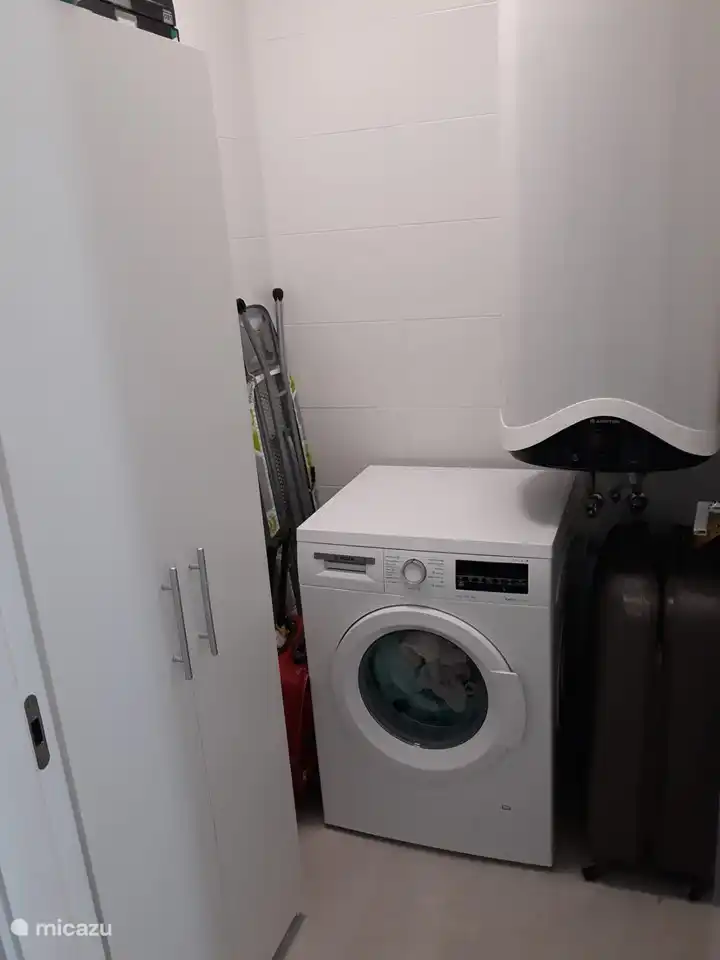 Petit espace de rangement avec machine à laver avec espace pour votre valise et votre chariot. Planche à repasser, fer à repasser, aspirateur...