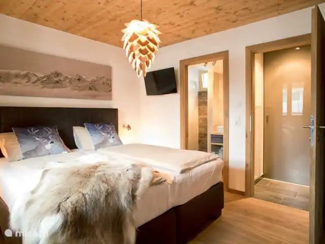 Résidence Neukirchen | Autriche, Salzburgerland, Neukirchen am Grossvenediger - appartement Lit de maître avec télévision et salle de bain attenante