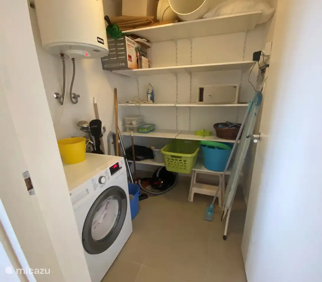 Laundry room with washing machine, iron, ironing board, vacuum cleaner etc