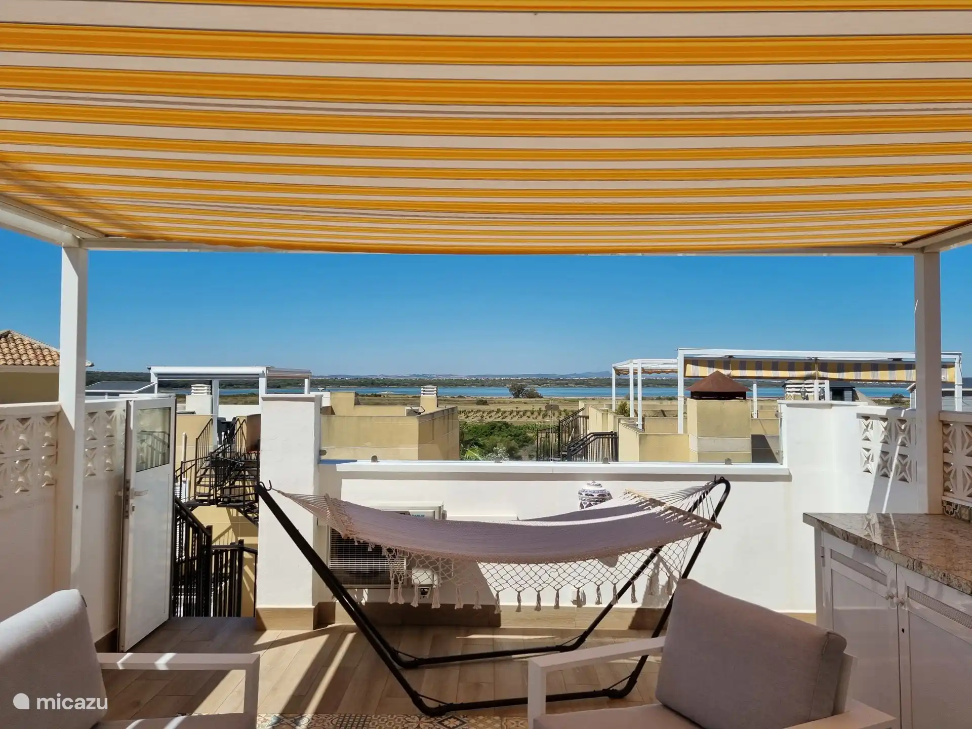 Wie schön ist es, auf der Dachterrasse zu entspannen! Eine Küche mit einem Kühlschrank, Markisen, einem luxuriösen Lounge-Set mit 2 Sonnenliegen und einer Hängematte ist ebenfalls vorhanden. Hier können Sie sich entspannen!  